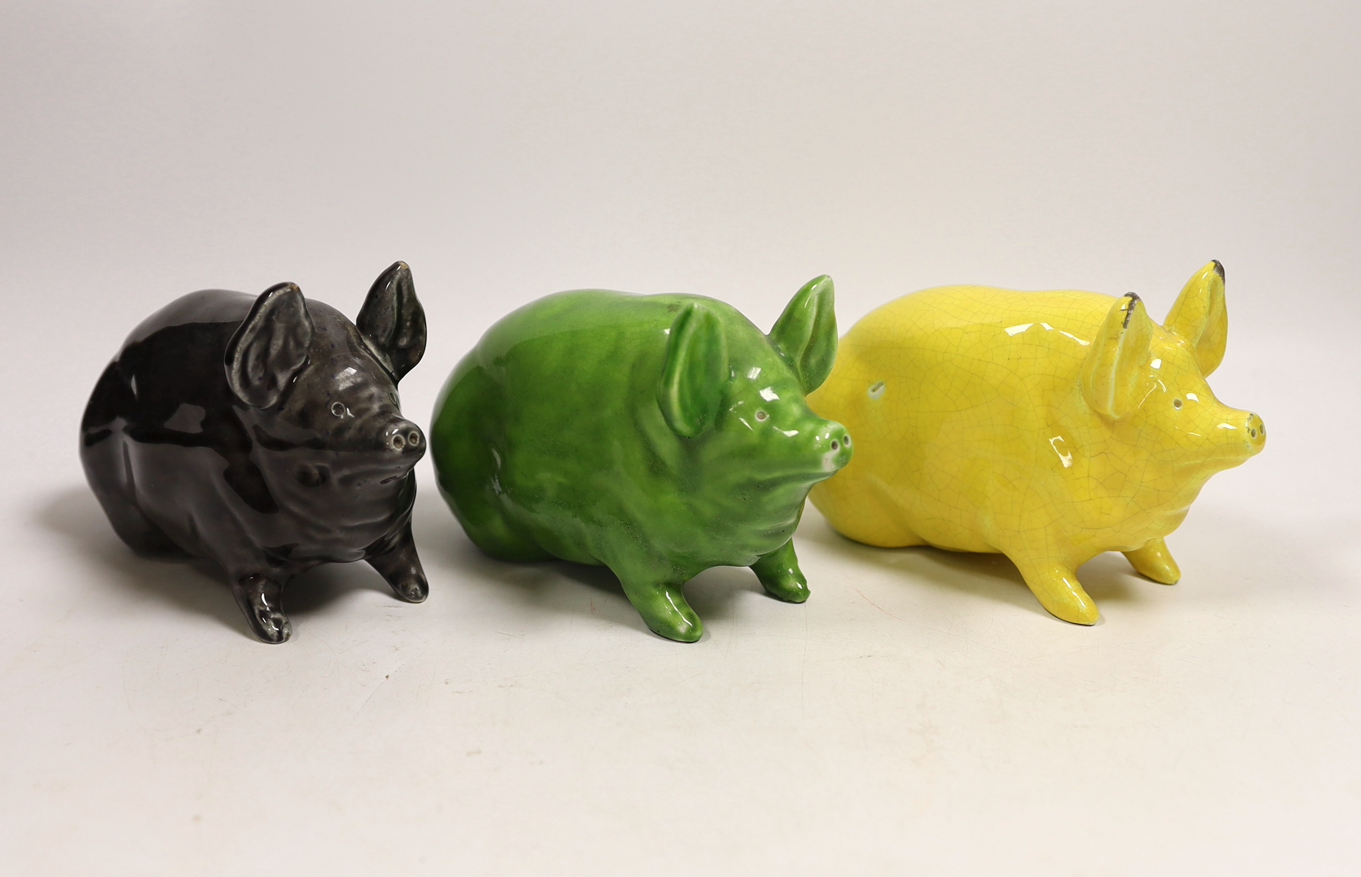 Three Wemyss ware pigs in green, yellow and black glazes, 15cm